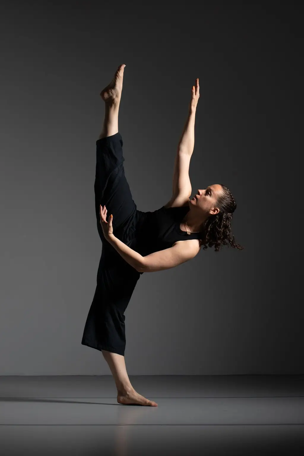 ecole-de-danse-jarnac.-2 Une femme en noir effectue un pas de danse avec grâce et énergie